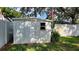 Outdoor storage shed with secure door and window, adjacent to a white fence and lush green lawn at 7336 20Th N St, St Petersburg, FL 33702