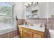 Bathroom with vintage-style pink tile, wood vanity, medicine cabinet and plenty of natural light from the window at 757 32Nd N Ave, St Petersburg, FL 33704