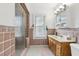 Bathroom with vintage-style pink tile, glass-enclosed shower, wood vanity and plenty of natural light from the window at 757 32Nd N Ave, St Petersburg, FL 33704