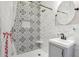 Modern bathroom featuring a patterned tile shower with a built-in niche, contemporary vanity and a round mirror at 757 32Nd N Ave, St Petersburg, FL 33704