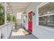 Inviting front porch with gray wood flooring, white railings, and a vibrant red front door at 757 32Nd N Ave, St Petersburg, FL 33704