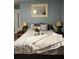 Cozy bedroom featuring neutral tones, comfortable bedding, and decorative artwork above the bed at 836 Magellan Dr, Sarasota, FL 34243
