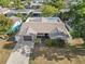 An aerial view of a cozy home featuring a well-manicured front yard, driveway and above ground pool in the back at 9218 Glen Moor Ln, Port Richey, FL 34668