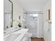 Bright bathroom with white vanity, marble tiled walls, and updated fixtures at 9218 Glen Moor Ln, Port Richey, FL 34668