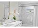 Bright bathroom with marble-look tile, updated vanity, and large mirror at 9218 Glen Moor Ln, Port Richey, FL 34668