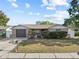 Charming single-story home featuring a well-kept lawn and a gray, one-car garage at 9218 Glen Moor Ln, Port Richey, FL 34668