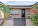 Inviting entryway with a black front door, decorative wreath, and lush landscaping at 9218 Glen Moor Ln, Port Richey, FL 34668