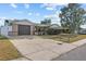 Well-maintained home with a spacious driveway, a manicured lawn, and mature landscaping, offering great curb appeal at 9218 Glen Moor Ln, Port Richey, FL 34668
