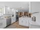 Open kitchen with white cabinets, stainless steel appliances, island and hardwood floors at 9218 Glen Moor Ln, Port Richey, FL 34668
