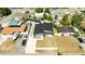 An aerial view shows a modern home with a dark roof, surrounded by a well-maintained lawn and mature trees at 10104 N Dartmouth Ave, Tampa, FL 33612
