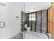 Updated bathroom with white tile shower, pebble floor, glass surround and fixtures at 1025 Boca Ciega Isle Dr, St Pete Beach, FL 33706