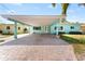 Charming home featuring a spacious carport and a brick driveway at 1025 Boca Ciega Isle Dr, St Pete Beach, FL 33706