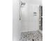 Updated shower with white subway tile, pebble floor and modern showerhead at 1025 Boca Ciega Isle Dr, St Pete Beach, FL 33706