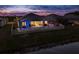 An aerial twilight view shows the pool area, fenced in back yard, and a pond behind the home at 10982 Banyan Breeze Blvd, Land O Lakes, FL 34638