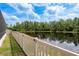 Scenic backyard view with well-maintained fence overlooking a peaceful pond and lush greenery at 10982 Banyan Breeze Blvd, Land O Lakes, FL 34638