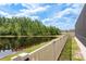 Scenic backyard view with fence overlooking a peaceful pond and lush greenery at 10982 Banyan Breeze Blvd, Land O Lakes, FL 34638