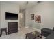 This cozy bedroom includes a mounted television, dark wood dresser, and modern, neutral decor at 10982 Banyan Breeze Blvd, Land O Lakes, FL 34638
