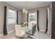 Elegant dining room featuring a glass table, modern chandelier, and neutral decor with views to the garden at 10982 Banyan Breeze Blvd, Land O Lakes, FL 34638