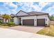Attractive single-story home with a tile roof, brick driveway, and a two-car garage, enhanced by lush landscaping at 10982 Banyan Breeze Blvd, Land O Lakes, FL 34638