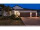 Charming single-story home with a tile roof, brick driveway, and well-manicured landscaping at twilight at 10982 Banyan Breeze Blvd, Land O Lakes, FL 34638