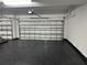 Spacious garage with insulated door featuring black epoxy floors with access to a storage room at 10982 Banyan Breeze Blvd, Land O Lakes, FL 34638