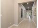 Spacious hallway with tile flooring, neutral walls, and decorative artwork at 10982 Banyan Breeze Blvd, Land O Lakes, FL 34638