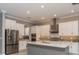 Modern kitchen with white cabinets, stainless steel appliances, a gray backsplash, and a kitchen island at 10982 Banyan Breeze Blvd, Land O Lakes, FL 34638