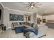 Comfortable living room with a large sectional sofa, ottoman, and a modern art piece on the wall at 10982 Banyan Breeze Blvd, Land O Lakes, FL 34638