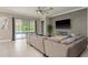 Stylish living room featuring tile floors, a modern ceiling fan, and sliding glass doors to the screened-in lanai at 10982 Banyan Breeze Blvd, Land O Lakes, FL 34638