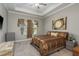 Comfortable main bedroom featuring a tray ceiling, large window, and coordinated decor and bedding at 10982 Banyan Breeze Blvd, Land O Lakes, FL 34638