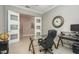 Modern office with glass desk, large clock, and double doors opening to the rest of the home at 10982 Banyan Breeze Blvd, Land O Lakes, FL 34638