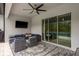 Stylish screened patio includes plush seating, an outdoor TV, and views of the pool and lush backyard at 10982 Banyan Breeze Blvd, Land O Lakes, FL 34638