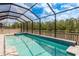 Beautiful pool with spa, enclosed lanai, overlooking a lush landscape and pond at 10982 Banyan Breeze Blvd, Land O Lakes, FL 34638