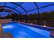 This expansive pool and spa area is encased within a large screened-in enclosure at twilight at 10982 Banyan Breeze Blvd, Land O Lakes, FL 34638