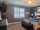 Comfortable bedroom with gray walls, white trim, and natural light from a window with white shutters at 11219 Paddock Manor Ave, Riverview, FL 33569