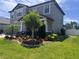 Beautifully landscaped yard featuring a decorative tree, mulch beds and manicured grass around the property at 11219 Paddock Manor Ave, Riverview, FL 33569