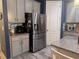 View of the kitchen with stainless steel refrigerator and gray cabinets with modern hardware at 11219 Paddock Manor Ave, Riverview, FL 33569