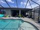 Relaxing pool area with pavers, covered patio and tropical landscaping at 11219 Paddock Manor Ave, Riverview, FL 33569