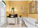 Bright bathroom featuring a clawfoot tub, decorative mirror, and elegant wall paneling at 11715 Taylor Rd, Thonotosassa, FL 33592