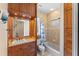 Bathroom with wooden cabinets, granite countertops, and a shower-tub combination with decorative tile at 11715 Taylor Rd, Thonotosassa, FL 33592