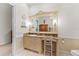 Bright bathroom with a vanity and makeup area, decorative mirror, and white walls and tiles at 11715 Taylor Rd, Thonotosassa, FL 33592