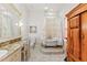 Bright bathroom with classic clawfoot tub, elegant vanity with makeup area, and decorative accents at 11715 Taylor Rd, Thonotosassa, FL 33592