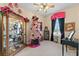 Cozy bedroom featuring a curio cabinet, themed Christmas Tree, and natural light at 11715 Taylor Rd, Thonotosassa, FL 33592