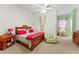Comfortable bedroom with wood bed frame, pink accents, and adjacent room with unique polka dot curtains at 11715 Taylor Rd, Thonotosassa, FL 33592