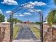 Elegant gated entrance with stone pillars and a long driveway leading to the residence at 11715 Taylor Rd, Thonotosassa, FL 33592