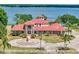 Stunning waterfront home with red tile roof, circular driveway, and lush landscaping at 11715 Taylor Rd, Thonotosassa, FL 33592
