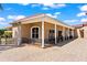 Home exterior featuring a covered patio with decorative columns and paver driveway at 11715 Taylor Rd, Thonotosassa, FL 33592