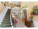 Elegant foyer featuring a grand staircase, arched doorways, and views of the kitchen and living spaces at 11715 Taylor Rd, Thonotosassa, FL 33592