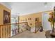 Upstairs hallway with decorative railings and various wall decor at 11715 Taylor Rd, Thonotosassa, FL 33592