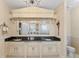 Elegant bathroom with dual sinks, a large mirror, granite countertops, and a view to the soaking tub at 11715 Taylor Rd, Thonotosassa, FL 33592